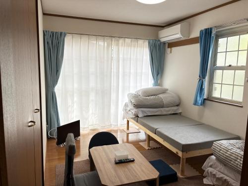 a room with a bed and a table and a window at メゾンドyy寺田 アパート1室貸切 素泊まり最大6人宿泊可能 4名様まで同一料金 in Yamaguchi