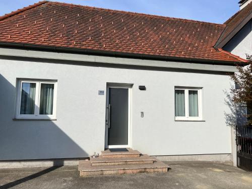 a white house with a black door and stairs at Modernes 3-Zimmer Appartement in Wels