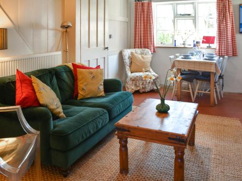a living room with a green couch and a table at The Buttery in Buxton