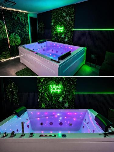 a jacuzzi tub in a room with green lights at Ô Spa Privatif - Luxury Suite - JACUZZI-SAUNA-NETFLIX-FISHSPA-SERVIETTES-PEIGNOIRS-SANDALES-CAFE in Morlanwelz-Mariemont