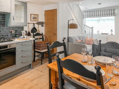 a kitchen and dining room with a table with glasses on it at Ernies in Haverigg