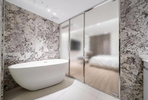 a bathroom with a white tub and a glass shower at 서초 Hotel Brick in Seoul