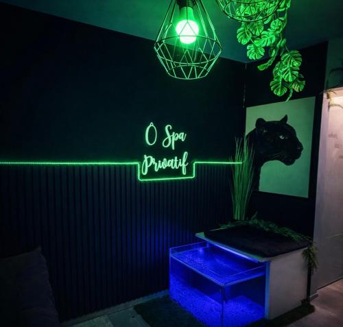 a neon sign in a room with a cat and a plant at Ô Spa Privatif - Luxury Suite - JACUZZI-SAUNA-NETFLIX-FISHSPA-SERVIETTES-PEIGNOIRS-SANDALES-CAFE in Morlanwelz-Mariemont