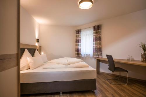 a hotel room with a bed and a desk at Aparthotel AlpTirol in Kaltenbach