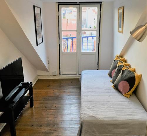 a small bedroom with a bed and a window at Casa de Cima in Lisbon