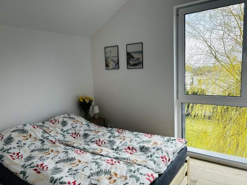a bedroom with a bed and a window at Apartamenty Dostoja in Władysławowo
