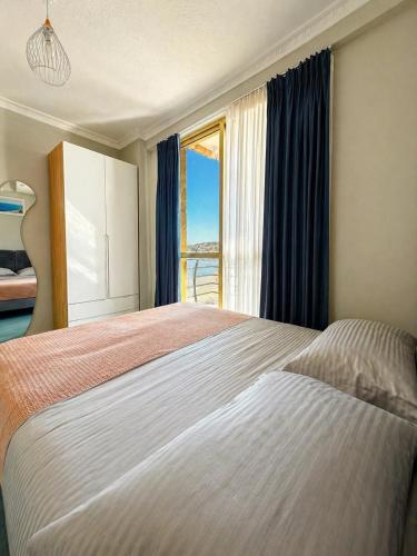 a bedroom with a large bed with a window at Eri Apartments 2 in Shëngjin