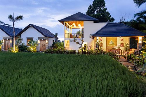a house with a green lawn in front of it at Ascarya Villa Ubud in Ubud