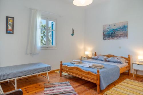 a bedroom with two beds and a window at Hippocrates' House in Amorgos
