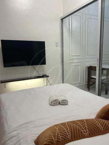 a bedroom with a bed with two towels on it at Cobblestone Properties - SM Mezza 1 Residences in Manila