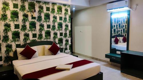 a bedroom with a bed and a wall with plants at Royal shades kodihali in Bangalore