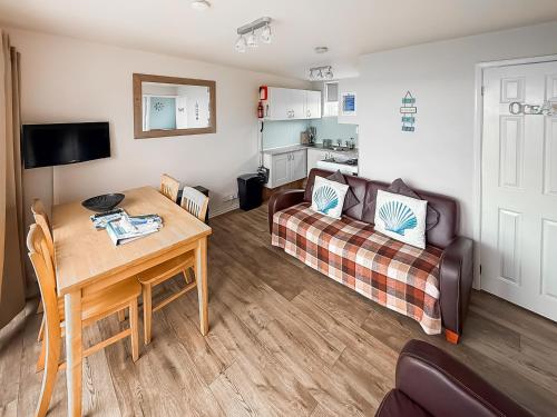 a living room with a couch and a table at No 4 Hickling Chalet - Uk51729 in Scratby