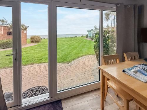 a sliding glass door with a view of the ocean at No 4 Hickling Chalet - Uk51729 in Scratby