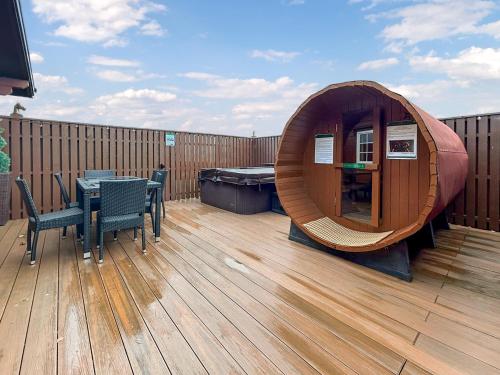 a wooden deck with a table and a sauna at Lodge 3 - Uk51250 in Glasgow