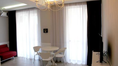 een eetkamer met een tafel en witte stoelen bij Happy Apartment 7 in Tbilisi City