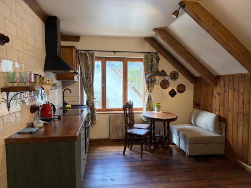 a kitchen with a table and a couch in a room at Zelta Apelsīna Rezidences in Kuldīga