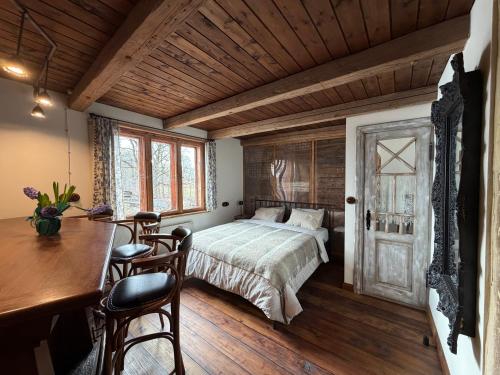 a bedroom with a bed and a table and chairs at Zelta Apelsīna Rezidences in Kuldīga