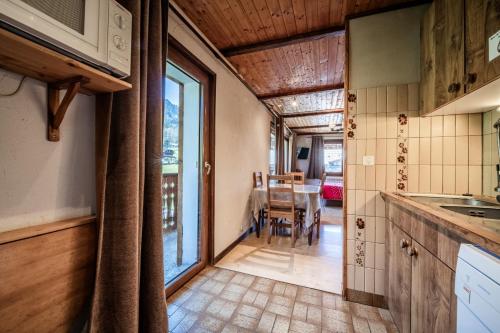 una cucina con una grande finestra e un tavolo di Les Cornettes de Bise a La Chapelle-dʼAbondance