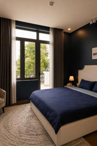 a bedroom with a blue bed and a large window at Hotel Gia Hưng in Bảo Lộc