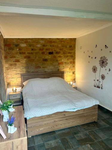 a bedroom with a bed and a brick wall at Levendulásház Palkonya in Palkonya