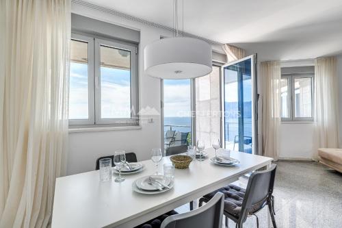 a dining room with a white table and chairs at Blue Seacliff Luxe in Komoševina