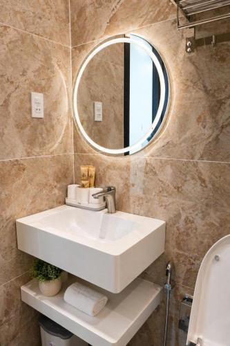 a bathroom with a white sink and a mirror at Hotel Gia Hưng in Bảo Lộc