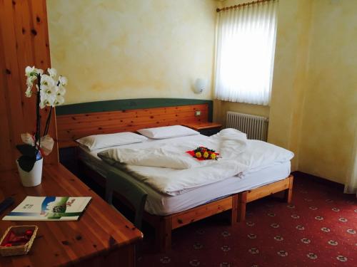 a bedroom with a bed with flowers on it at Hotel Stella Montis in Campitello di Fassa