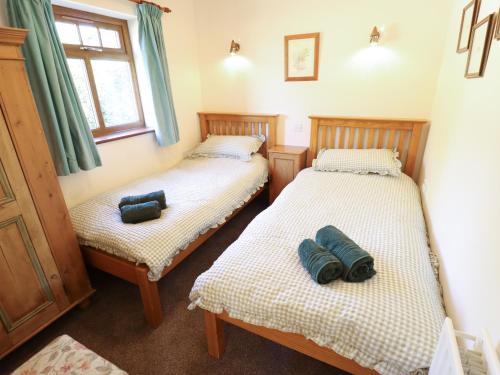 two twin beds in a room with a window at Kingfisher in Louth