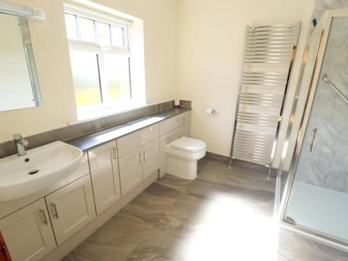 a bathroom with a sink and a toilet and a window at Kingfisher in Louth