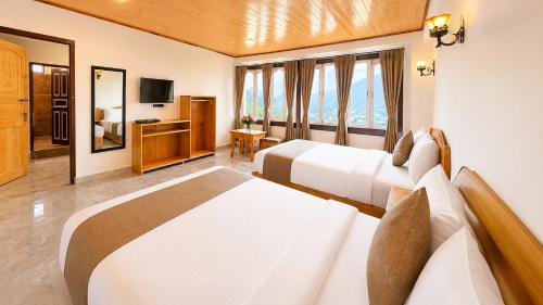a hotel room with two beds and a television at Sumitel Sonam Lachung in Lachung