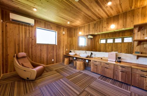 a bathroom with wooden walls and wooden floors and a chair at Kisara Oneness in Toba