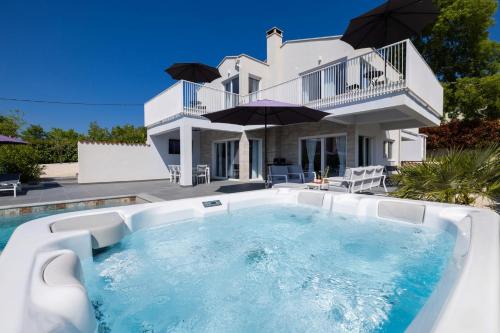 a villa with a swimming pool in front of a house at Casa Belladonna by Briskva in Višnjan