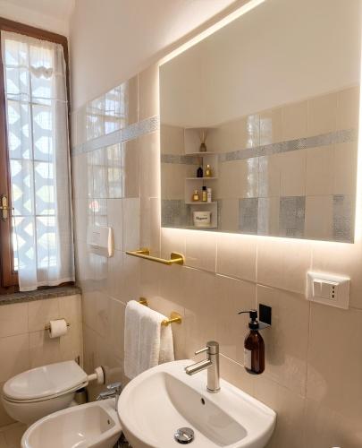a bathroom with a sink and a toilet and a mirror at ZenZone House in La Spezia