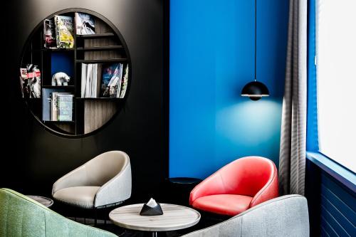 a room with two chairs and a table and a mirror at Hostellerie Du Chapeau Rouge in Dijon