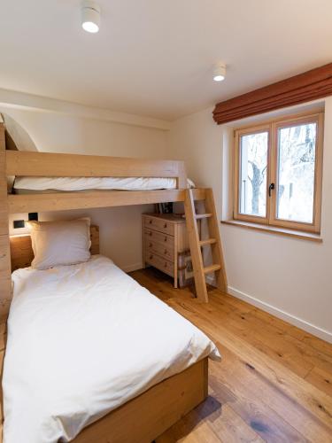 a bedroom with two bunk beds and a window at La Parenthèse du Goûter - by Care Concierge in Les Houches