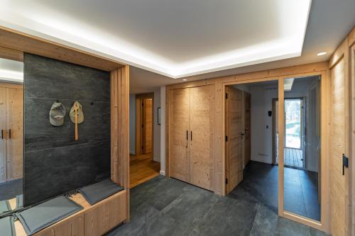 a room with wooden cabinets and a wall with ajar doors at La Parenthèse du Goûter - by Care Concierge in Les Houches