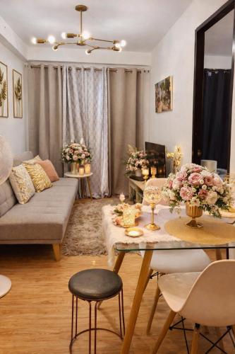 a living room with a couch and a table with flowers at Very Cozy Condo Davao in Davao City
