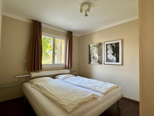 a bed in a bedroom with a window at Casa Sole in Gambarogno