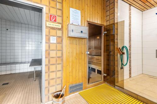 a shower with a yellow door in a bathroom at Nordseeblick in Bremerhaven