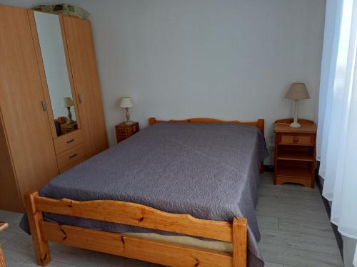 a bedroom with a wooden bed and two night stands at maison 6 personnes in Locquirec