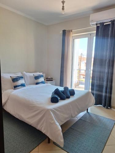 a bedroom with a large white bed with a window at Dimitra's APARTMENT NAFPLIO in Nafplio