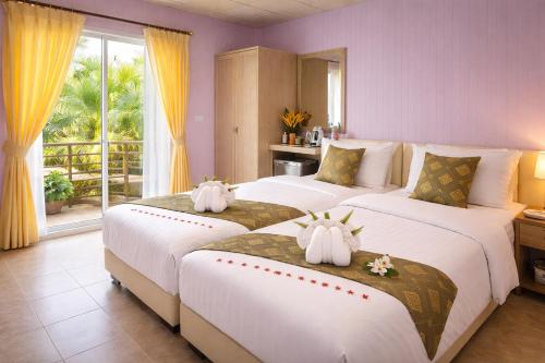 two beds in a hotel room with two large beds at Phetmanee Resort in Ko Yao Noi