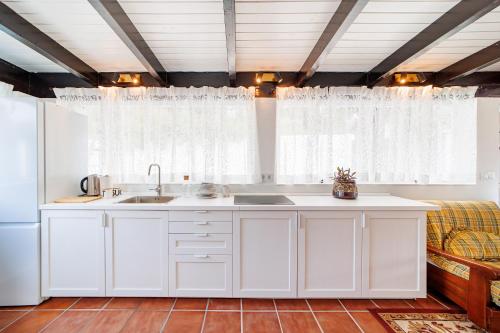 a kitchen with white cabinets and a sink at Sierra Blanca Bungalow in Marbella