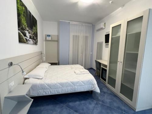 a small bedroom with a bed and a desk at Hotel La Giara in Zambrone