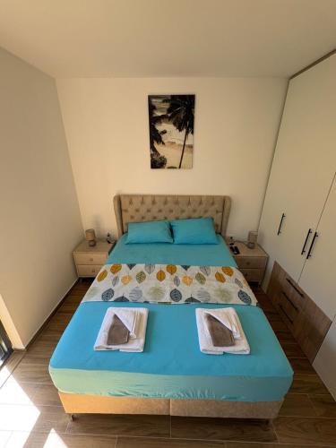 a bedroom with a blue bed with two towels on it at Ivanovica in Đenovići