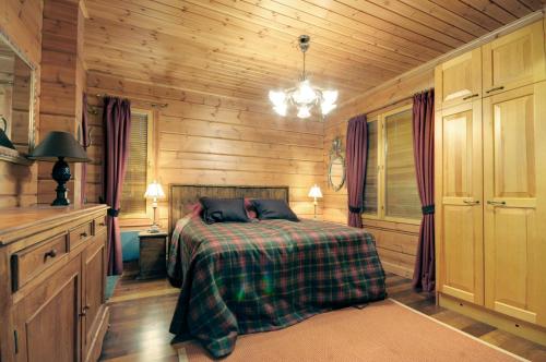 a bedroom with a bed in a wooden cabin at KULAUS in Tahkovuori