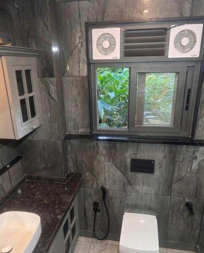 a bathroom with two sinks and a toilet and a window at The Pebble Shack in Idukki