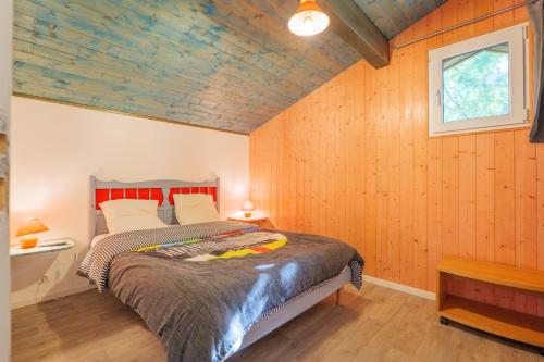 a bedroom with a bed in a room with wooden walls at Mas du soleil levant in Les Vans