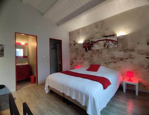 a bedroom with a large white bed and red lamps at Villa de l'Olivier in Aytré
