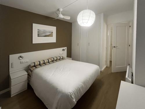 a bedroom with a white bed and a ceiling fan at Pedro in Roses